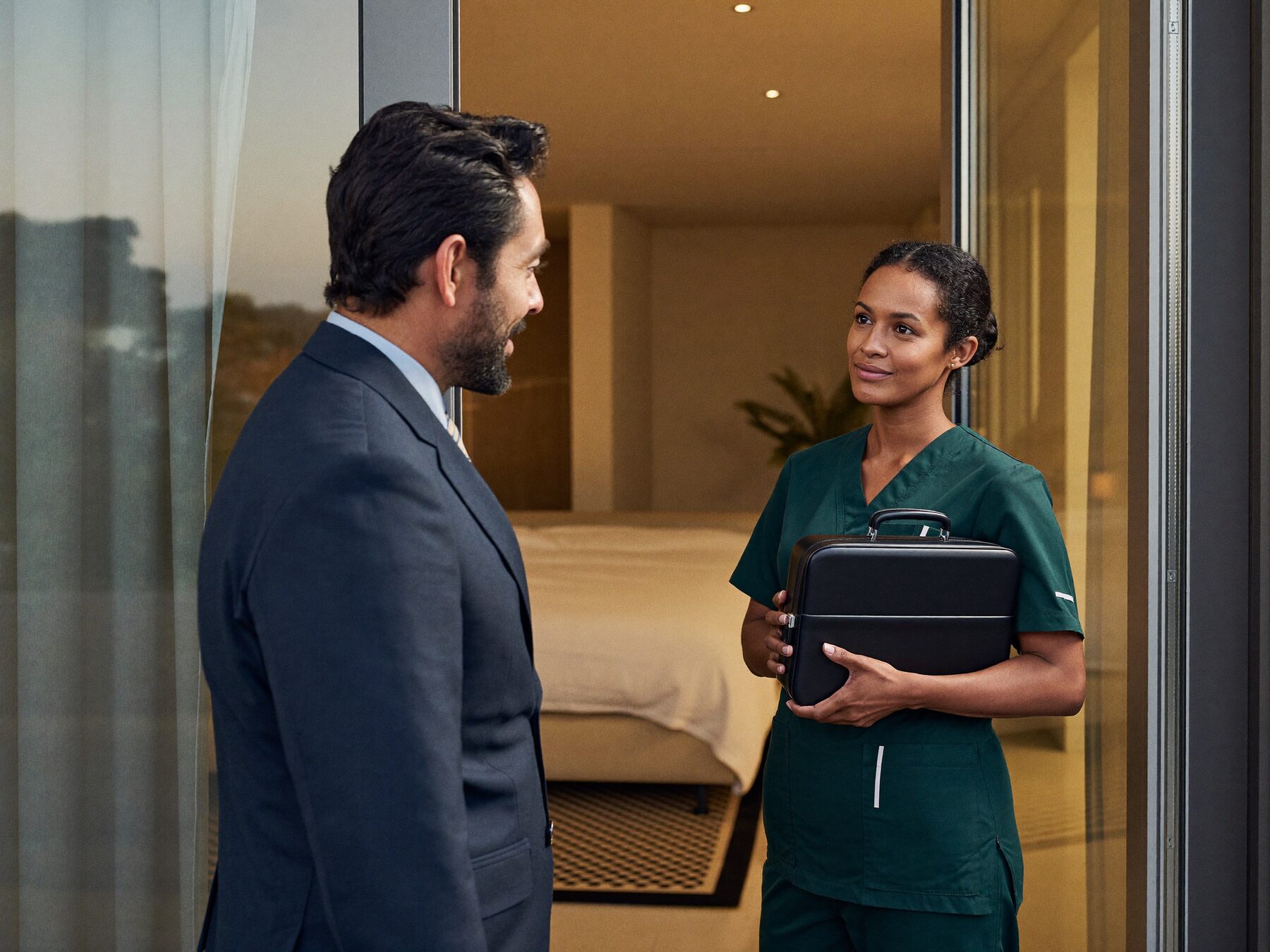 A Hollis physician and nurse arriving at a patient's apartment door in the evening